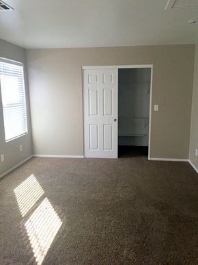 Las Vegas house for rent - an empty living room with a white door and carpet