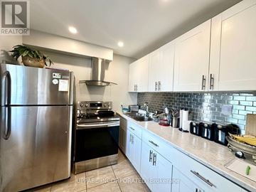 For rent in Ottawa - A kitchen with a stainless steel refrigerator and white cabinets.