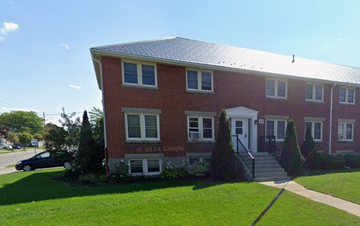 Oshawa apartment for rent - A red brick house with a white door and windows.