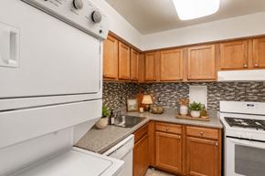 Parkville townhouse for rent - A white oven in a kitchen with wooden cabinets.