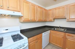 Laurel apartment for rent - A kitchen with a white stove and wooden cabinets.