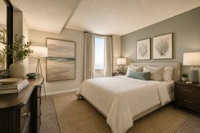 Newport News apartment for rent - A bedroom with a large bed, a nightstand, and a painting on the wall.