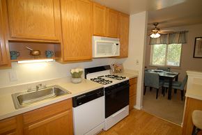 Parkville apartment for rent - A kitchen with wooden cabinets and a white stove top oven.