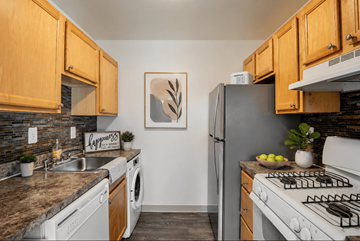 Laurel apartment for rent - A kitchen with a washing machine, a fridge, a stove and a sink.