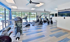 Parkville apartment for rent - a gym with cardio equipment and windows with a view of a pool