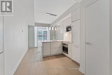 Ottawa house for rent - A spacious kitchen with white cabinets and a wooden floor.