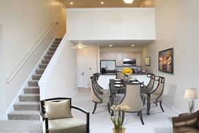 Norwood townhouse for rent - a dining room with a table and chairs in front of a staircase