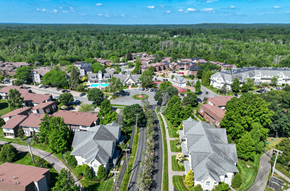 Norwood townhouse for rent - A bird's eye view of a residential area with houses and a swimming pool.