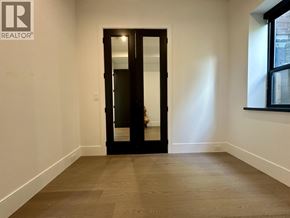 Vancouver house for rent - A room with a wooden floor and a black door.
