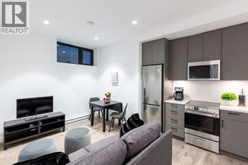 Vancouver other for rent - A modern living room with a grey couch and a television.