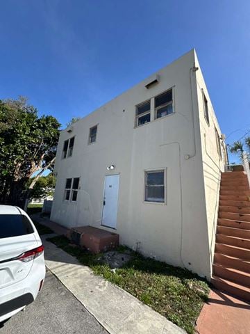 Hollywood apartment for rent - A white house with a car parked in front.