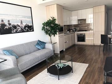 Burnaby apartment for rent - A living room with a grey couch and a glass table.