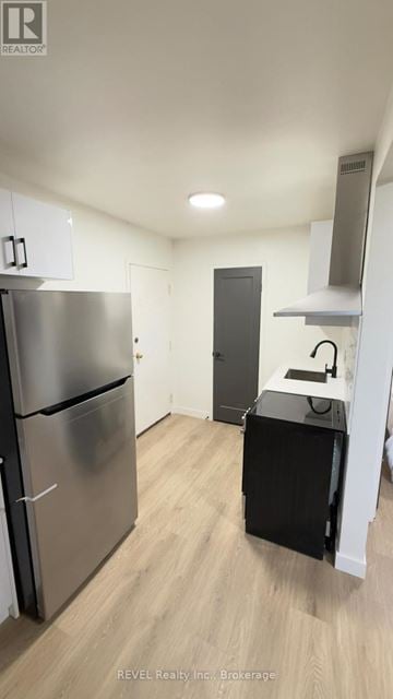 Toronto (Roncesvalles) condo for rent - A kitchen with a stainless steel refrigerator and a black dishwasher.