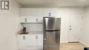 Toronto (Roncesvalles) condo for rent - A kitchen with white cabinets and a stainless steel refrigerator.