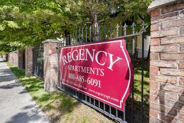 Salt Lake City apartment for rent - A sign for Regency Apartments is displayed on a fence.