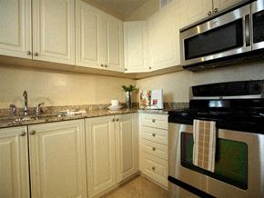 Toronto apartment for rent - A kitchen with white cabinets and a black stove top oven.