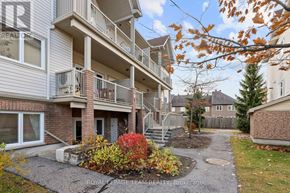 Ottawa condo for rent - A building with a balcony and a small garden in front.