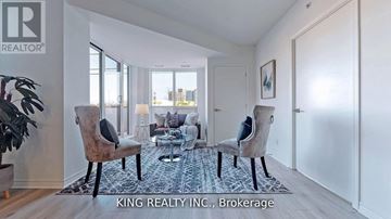 Toronto (West Hill) condo for rent - A living room with a couch, chairs, and a rug in front of a window.