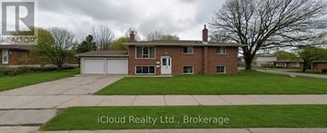 Waterloo duplex for rent - A kitchen with white cabinets and a window overlooking a road.