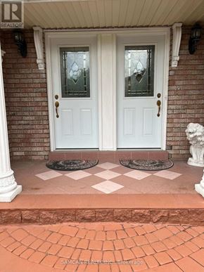 Oakville (Cv Clearview) house for rent - A white double door with glass panels and sidelights is set in a brick wall.