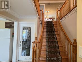 Oakville (Cv Clearview) house for rent - A staircase with a wooden banister and a chandelier in the background.