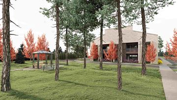 Troy apartment for rent - A building is surrounded by trees with red leaves.