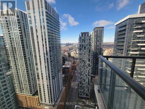 Toronto (Waterfront Communities) condo for rent - A cityscape with skyscrapers and a clear sky.