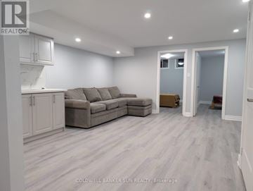 Whitby (Lynde Creek) house for rent - A living room with a grey couch and a white cabinet.