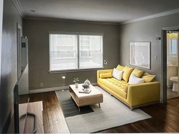 Long Beach apartment for rent - A living room with a yellow couch and a wooden coffee table.