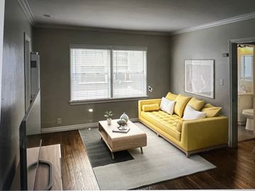 Long Beach apartment for rent - A living room with a yellow couch and a wooden coffee table.