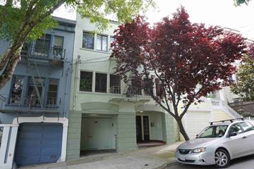 San Francisco apartment for rent - A tree with red leaves is in front of a white house.