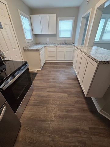 Lima apartment for rent - A kitchen with a black stove top oven and white cabinets.