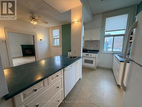 Penetanguishene multi-family for rent - A kitchen with white cabinets and a black countertop.