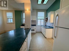 Penetanguishene multi-family for rent - A kitchen with a black countertop and white appliances.