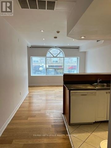 Toronto (Greenwood-Coxwell) house for rent - A kitchen with white cabinets and a black countertop.