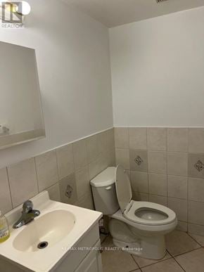 Toronto (Greenwood-Coxwell) house for rent - A white toilet sits next to a sink in a small bathroom.