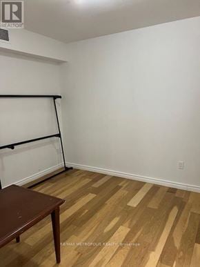 Toronto (Greenwood-Coxwell) house for rent - A room with a wooden floor and a table.