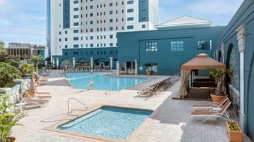 Orlando apartment for rent - A large swimming pool surrounded by lounge chairs and umbrellas.
