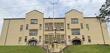 Glassport apartment for rent - A large, beige building with a symmetrical facade and a set of stairs leading up to the entrance.