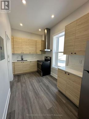 For rent in North Grenville - A modern kitchen with wooden cabinets and a grey floor.