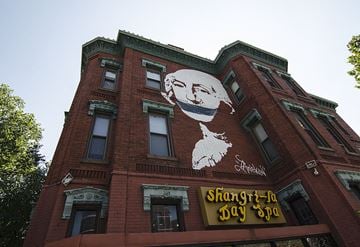 Washington apartment for rent - A red building with a large mural of a man's face and the words "Shangri-La Day Spa" written below it.
