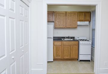 Washington apartment for rent - A kitchen with white appliances and wooden cabinets.