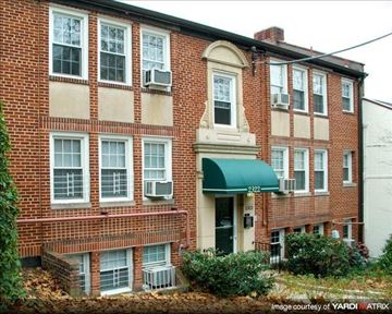 Washington apartment for rent - A red brick building with a green awning and a white door.