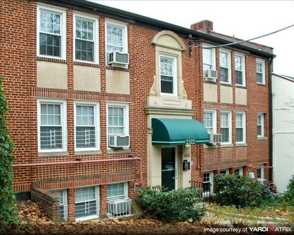 Washington apartment for rent - A red brick building with a green awning and a white door.