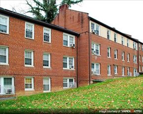 Washington apartment for rent - A red brick building with white windows and shutters.