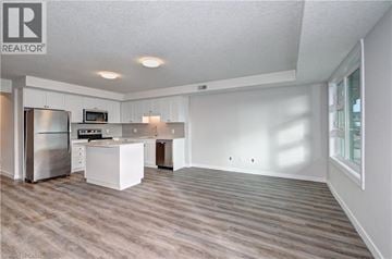 Kitchener townhouse for rent - A spacious kitchen with white cabinets and a stainless steel refrigerator.