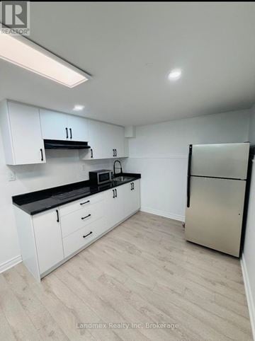 Mississauga (Meadowvale) house for rent - A kitchen with white cabinets and a black countertop.