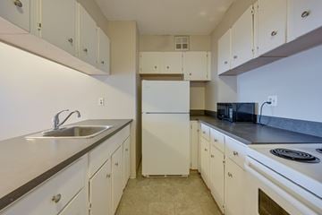 Edmonton apartment for rent - A kitchen with white cabinets and appliances.