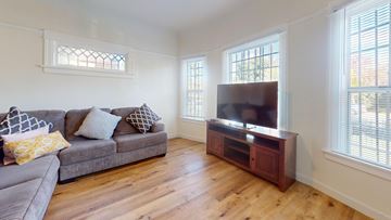 Los Angeles apartment for rent - A living room with a grey couch and a wooden cabinet.