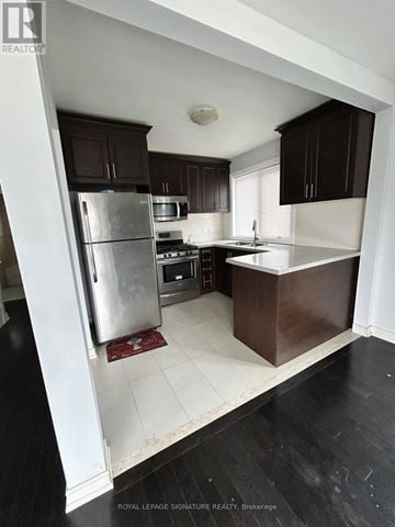 Toronto (Eglinton East) house for rent - A kitchen with a refrigerator, stove, and sink.